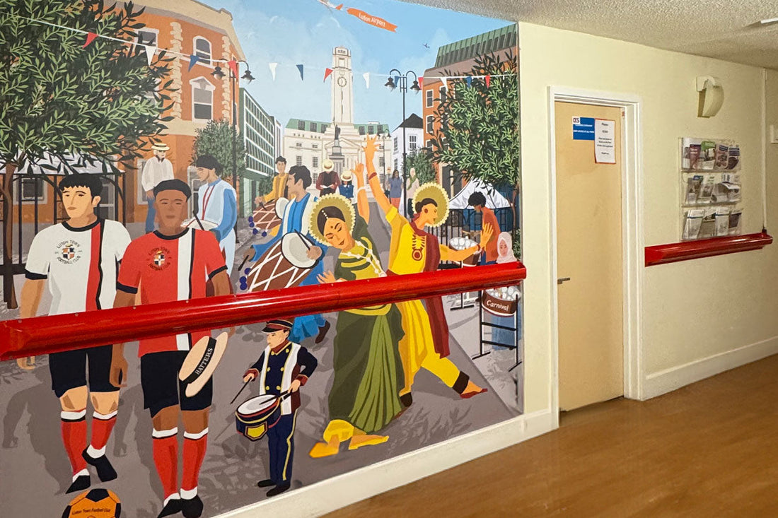 Luton Festival and Carnival corridor mural design by ATADesigns at Fountains Court, East London NHS Foundation Trust — featuring Luton Town FC players, dancers, drummers and the Luton clock tower
