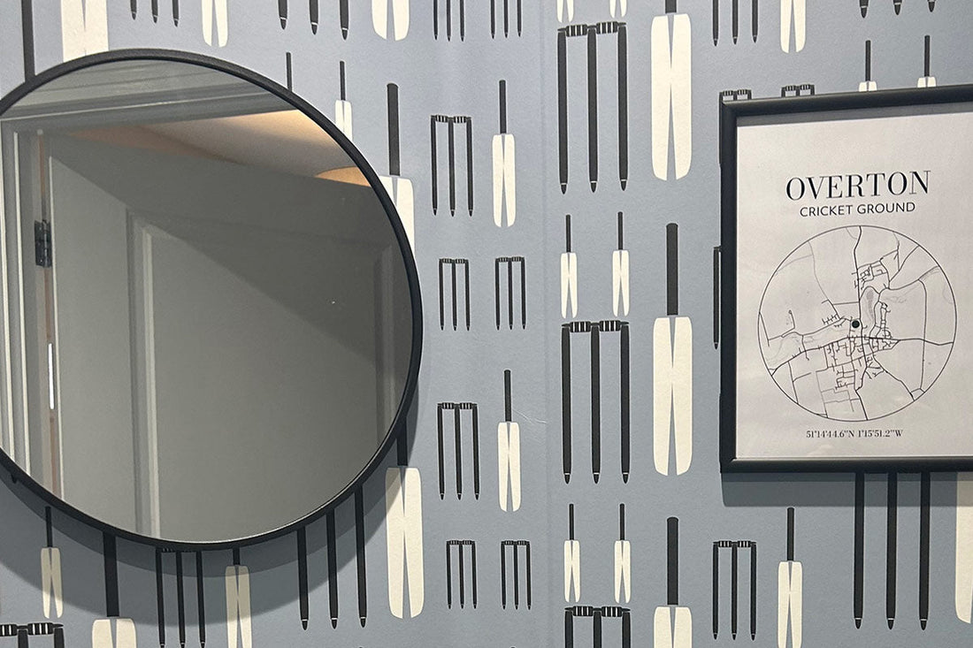 Cricket Wicket Wallpaper by ATADesigns installed in a residential bathroom — featuring a round mirror and framed picture on the wall