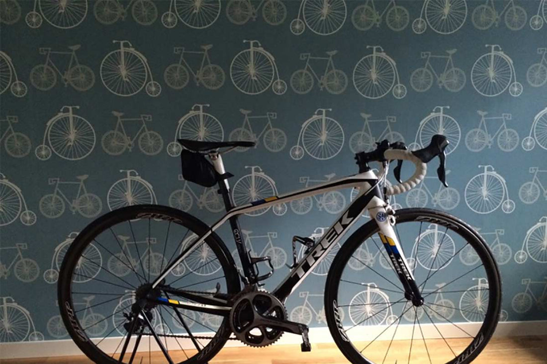 Bicycles wallpaper design by ATADesigns installed in a residential bike room in Sweden, with a road bike in front of the feature wall