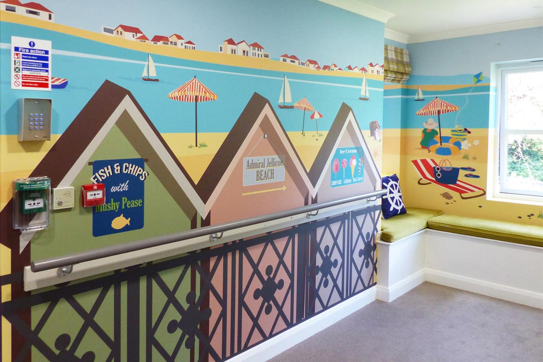 Panoramic bespoke beach mural installed by Paul Walden Interiors in the dementia care corridor at Admiral Jellicoe House, Portsmouth, designed by ATADesigns and printed by Wallsmiths