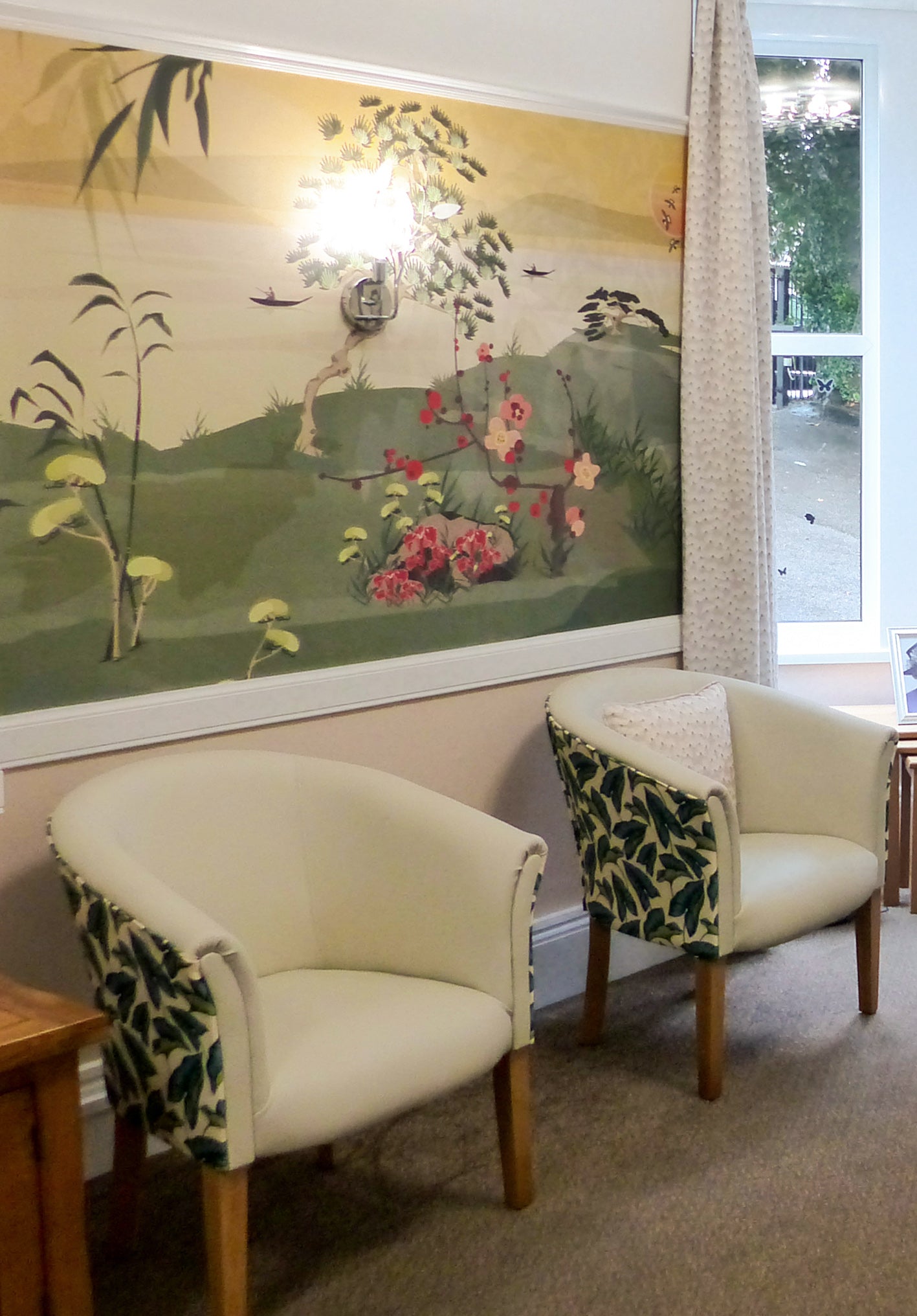 Two armchairs with leaf patterns in room with a large wall mural of a Japanese style nature and sea designed by ATADesigns for AbleCare