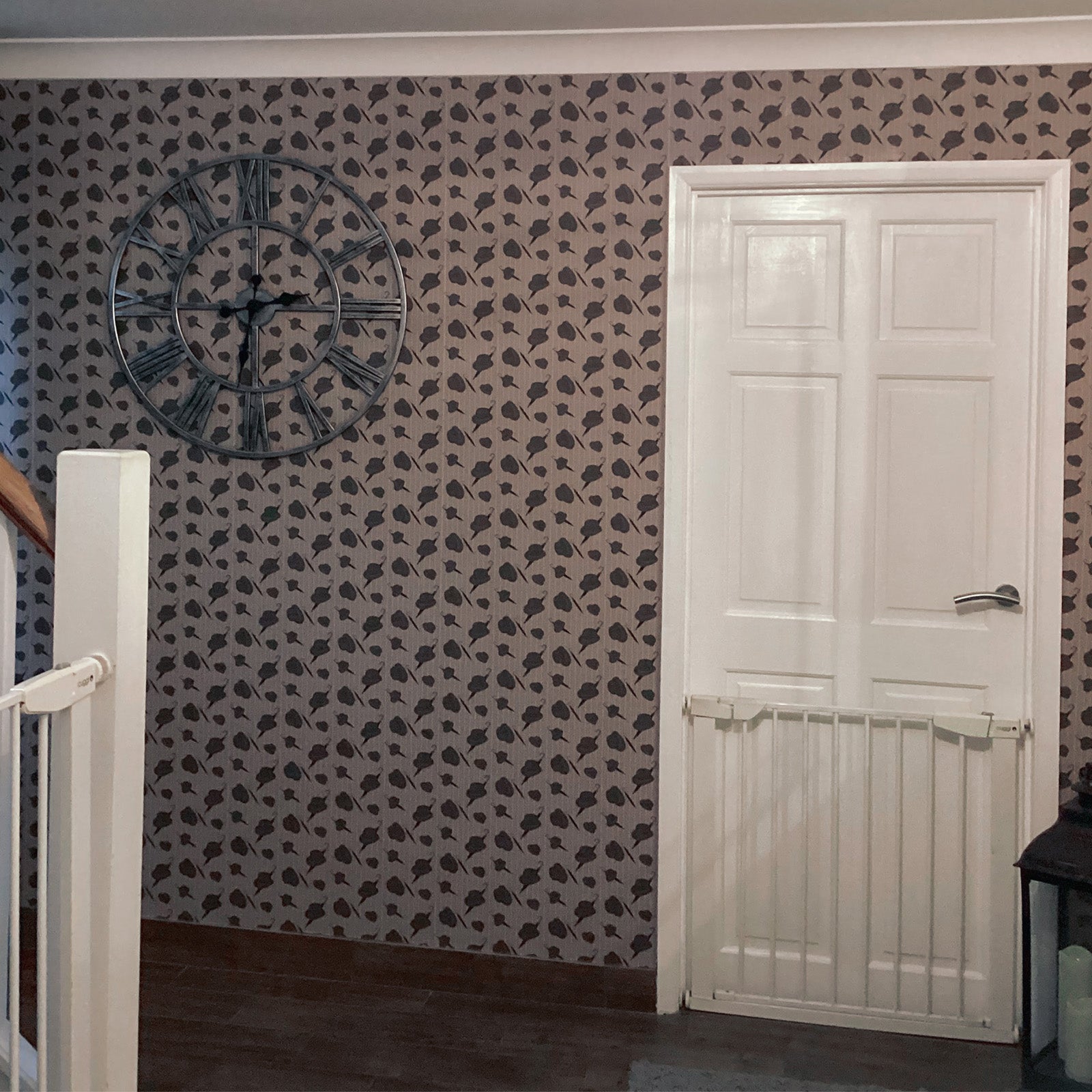 Hallway featuring white door and bannister with The Bowler wallpaper on wall around door.  The Bowler wallpaper design by ATADesigns.