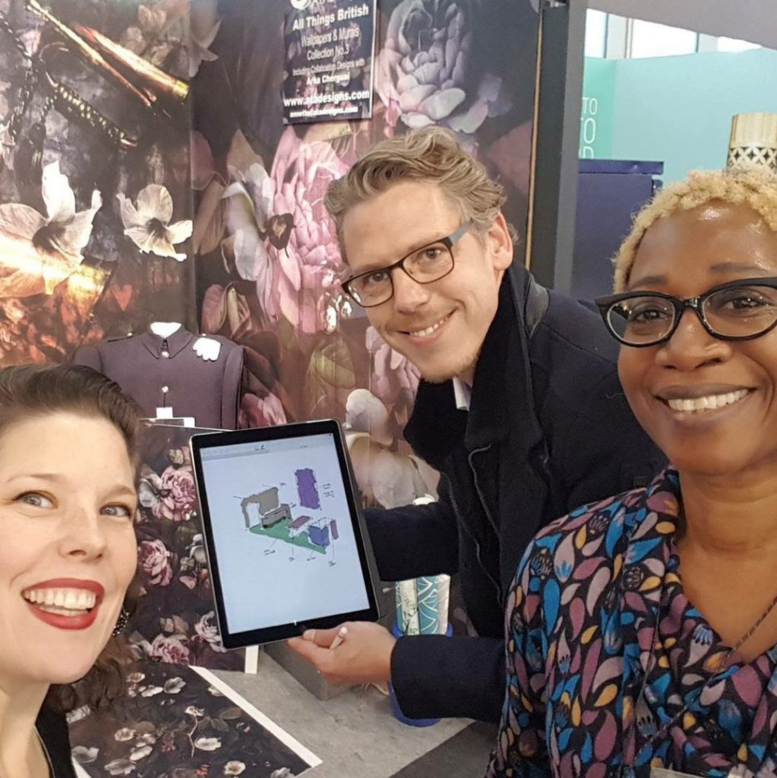 Jennifer Casodi, Clemens Hackl and Annette Taylor-Anderson smiling and posing for the camera holding a tablet computer.