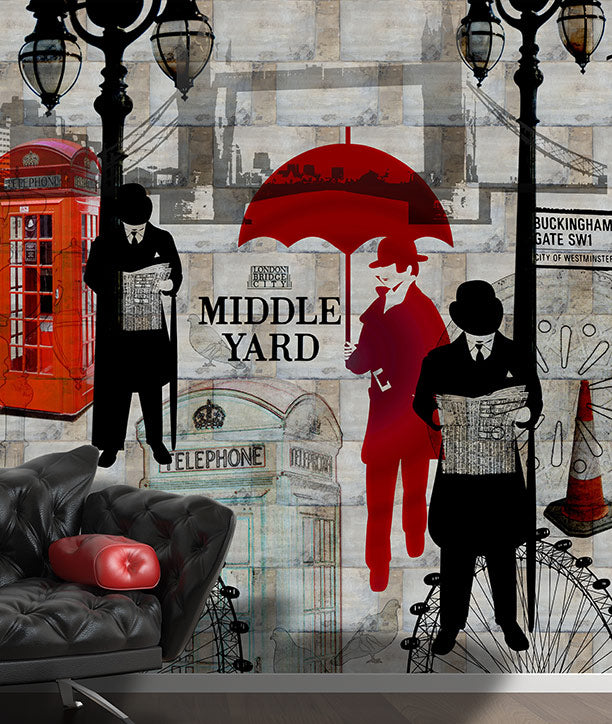 A London-themed wall mural or wallpaper featuring vintage street elements including red telephone booths, black lampposts, a red umbrella, silhouetted figures reading newspapers, and the text 'MIDDLE YARD' over a grey brick-patterned background. A black leather sofa with a red cushion is shown in the foreground as a styling element. Mural design by ATADesigns.