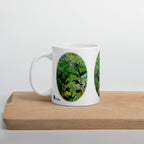 Pure Nature mug with green foliage and bird artwork, displayed on a wooden board.
