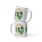 Two stacked white Tennis Deuce mugs by ATADesigns, showing tennis-player silhouettes and rackets on green backgrounds.