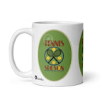 White Tennis Season mug with crossed black rackets, yellow tennis balls and red lettering on green, handle on the left.