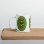 White Tennis Season mug with crossed rackets, yellow tennis balls and green artwork, displayed on a wooden board.